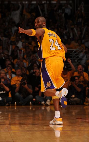 Kobe Bryant runs back on defense and points to a teammate for a good