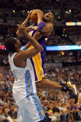 Kobe Bryant goes in for a double clutch shot against Nene.jpg