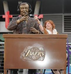 Marge Hearn holds up a microphone to Chick Hearn's statue.JPG