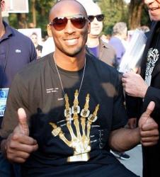 Kobe Bryant gives two thumbs up wearing t-shirt with x-ray hand with five rings.JPG