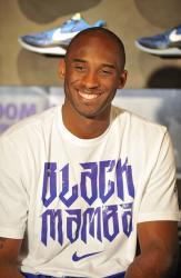 Kobe Bryant smiles in a white Black Mamba t-shirt.JPG