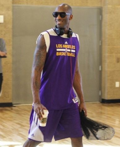 Kobe Bryant in sunglasses headphones and purple Laker warmups holding coffee.JPG
